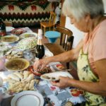 An elderly woman preparing a nutritious meal in her home with support