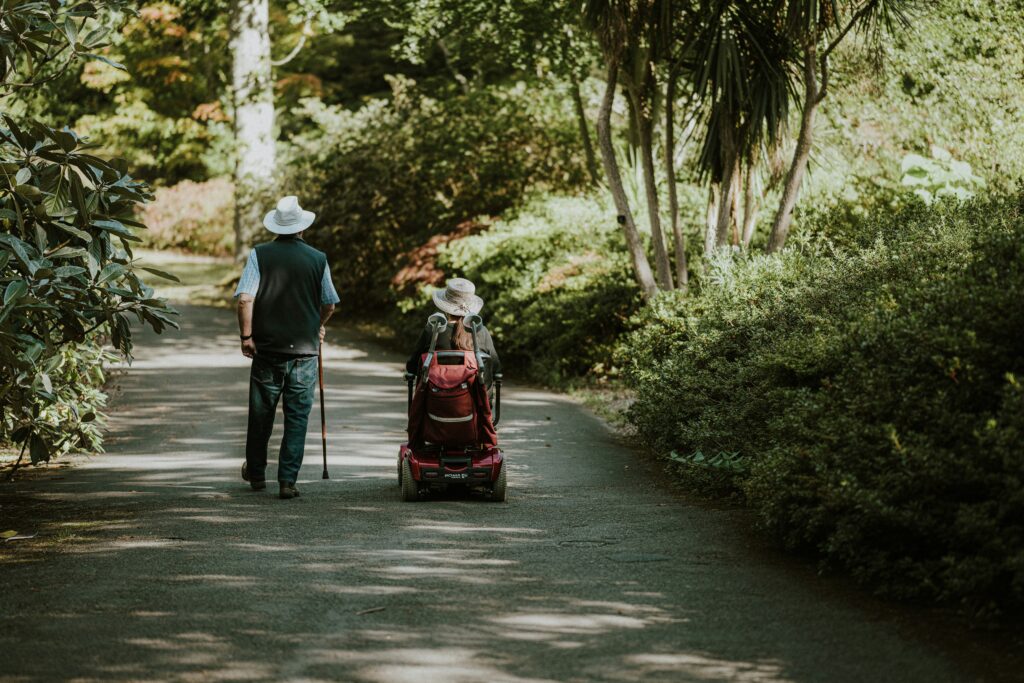 Two elderly people walking in a park